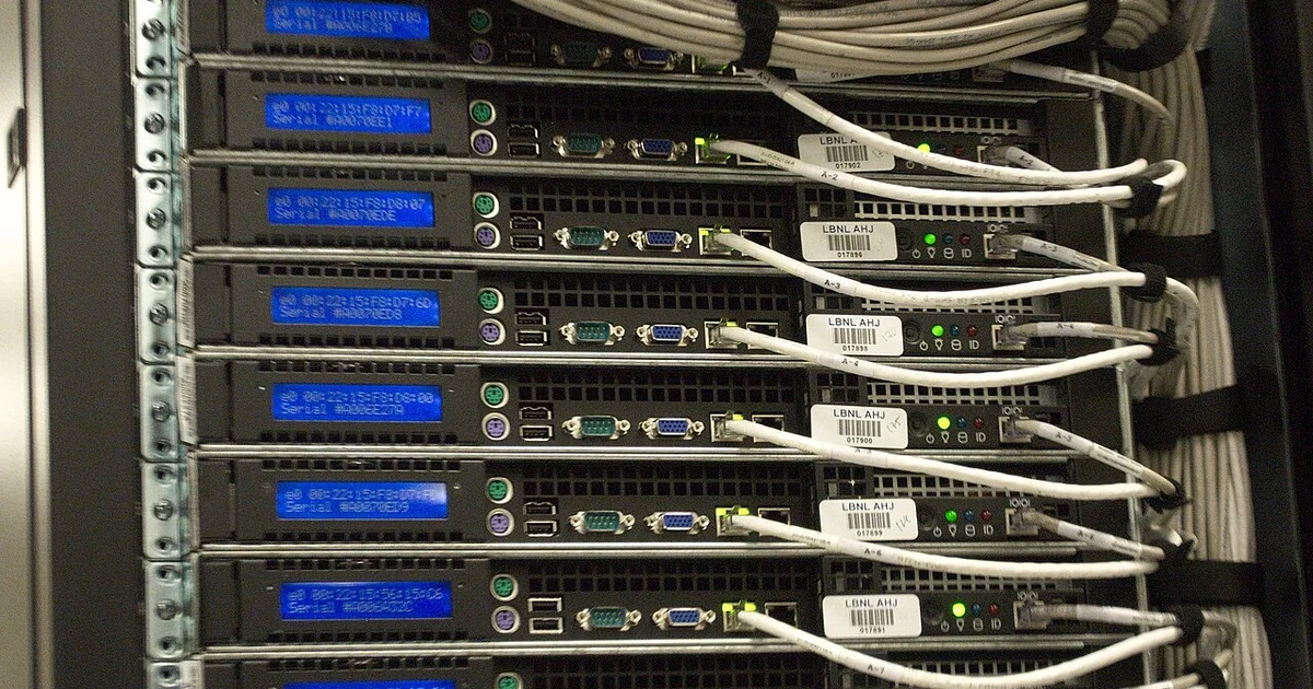 Showing blue LED screens giving MAC address and serial number. White cables are Ethernet cables. Each server features commodity PC outlets including a serial port, VGA port, PS/2 ports, and USB ports. CC0 waiver: To the extent possible unde